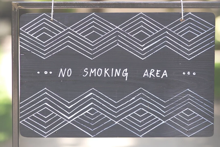 A sign reads no smoking area with geometric design.
